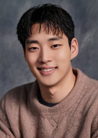 Asian man smiling in a sweater.