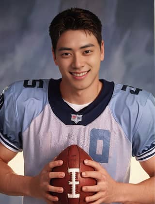 Man in a football uniform holding a football.