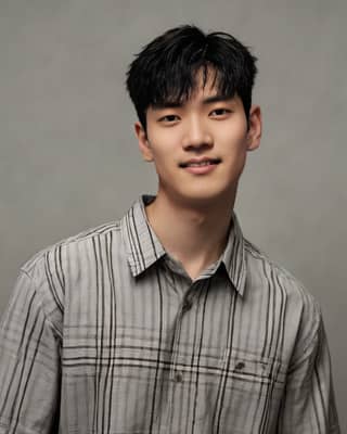 Man in plaid shirt smiling, model and singer of Korean drama.