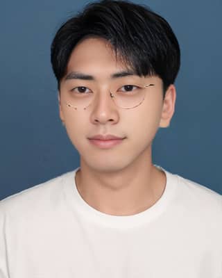 Hombre con gafas y una camiseta blanca posando para una foto con un fondo azul.