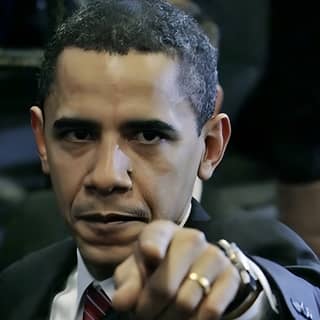 President Obama wearing a suit and tie points at the camera.