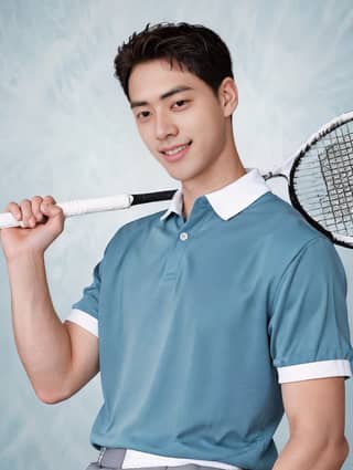 man in a blue shirt holding a tennis racket and smiling