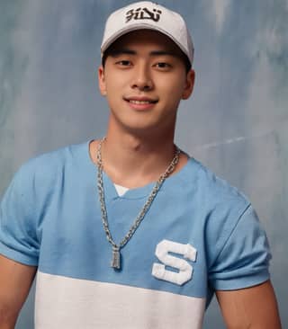 A man in a blue shirt and white hat wearing a baseball cap posing for a picture.