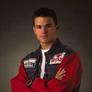 man in a red and blue jacket and white shirt posing for a picture