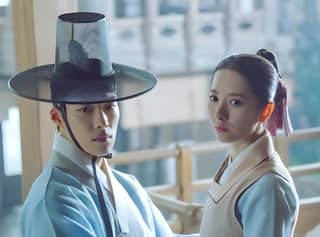 Il drama coreano The King and I presenta due persone vestite con abiti e cappelli tradizionali.