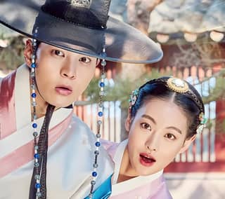 Two women wearing traditional Korean clothing pose for a picture.