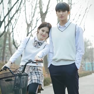 Un couple pose pour une photo avec un vélo dans le parc.