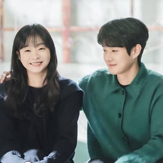 Un couple assis sur un banc ensemble, souriant.