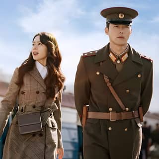 A man and woman in military uniforms are walking together.