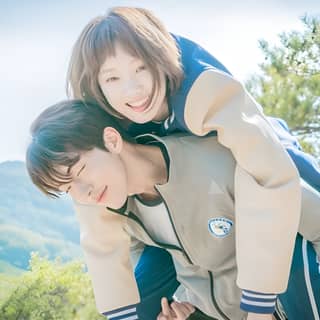 A woman and a girl are posing together in the mountains.