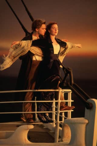 Una mujer se encuentra en la cubierta de un barco, viendo una película.