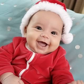 a smiling baby in a santa hat