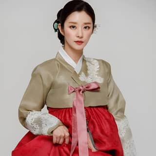 poses in traditional Korean clothing for a photo.