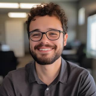 https://s mj short curly hair glasses brown eyes white male scruffy beard nice smile sitting inside of a corporate office