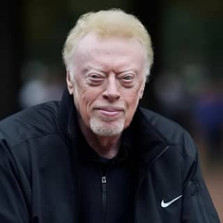 Phil Knight ngồi trên một ghế công viên.