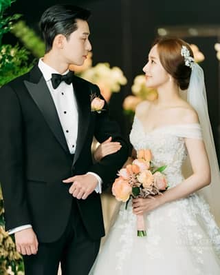 a bride and groom in formal attire standing together