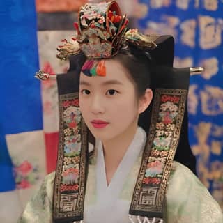 in traditional korean clothing is posing for a photo