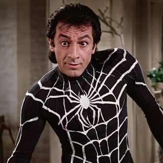 Persona indossa il costume di spider-man davanti allo specchio.