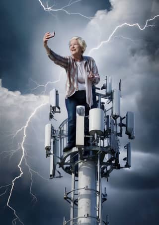 is standing on top of a cell tower with lightning