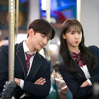 two young people in school uniforms pose for a photo