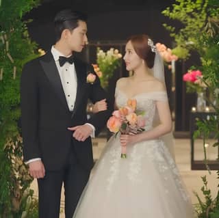 a bride and groom standing in front of a wedding arch