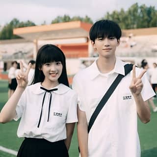 a couple posing for a picture on a soccer field