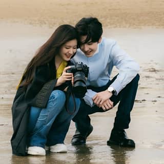 a couple taking pictures on the beach