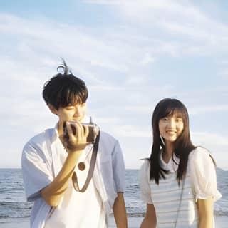 a couple taking pictures on the beach