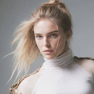 a blonde woman in a white top and gold top