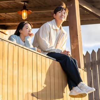 a couple sitting on a porch looking out at the sky